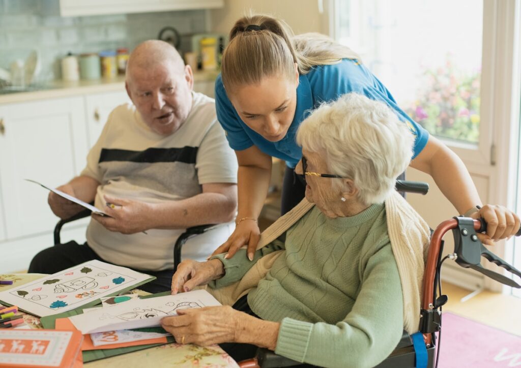 Caregiver assisting elderly couple with a meaningful activity at home — dementia home care Burlington Ontario